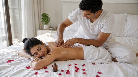 Indian couple romantic back massage at home with massage oil and rose petals on white bed