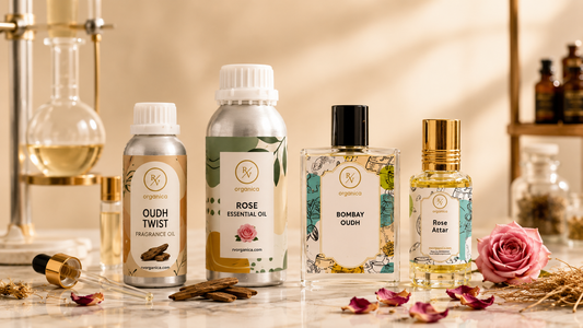 Rose essential oil, Oudh Twist fragrance oil, Bombay Oudh perfume and Rose Attar bottles with natural rose petals and oud wood in a professional product photography setup