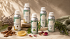 Premium RV Organica essential oil collection featuring lavender, peppermint, cedarwood, tea tree, and rosemary essential oil aluminum bottles arranged with fresh botanicals on a warm textured surface in luxury organic product photography.