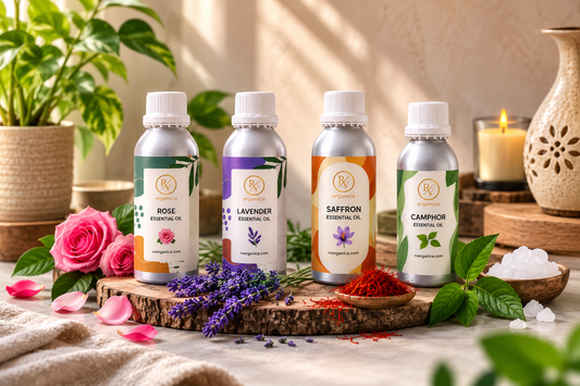 RV Organica Rose, Lavender, Saffron and Camphor Essential Oil bottles displayed in a natural spa setting with flowers, herbs and wooden decor.