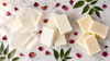Clear glycerin, ultra white and shea butter melt and pour  soap base blocks on marble surface with rose petals and  neem leaves - soap making supplies by RV Organica Haryana