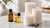 Fragrance oils for candle making with amber glass bottles, white pillar candles and lavender sprig on marble surface