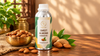 RV Organica Sweet Almond Carrier Oil bottle with almonds and green leaves on a warm wooden table in a traditional Indian kitchen setting.