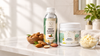 RV Organica Sweet Almond Carrier Oil and Almond Body Butter with raw almonds in a premium skincare bathroom setting