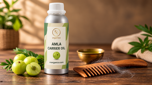 RV Organica Amla Carrier Oil bottle with fresh amla fruits, a wooden wide-tooth comb with grey hair strands, and a brass bowl of oil on a rustic wooden table.