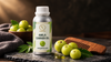 RV Organica Amla Carrier Oil aluminium bottle with fresh amla fruits and wooden beard comb on a dark slate surface in premium moody lighting.