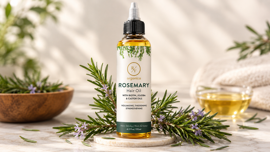 RV Organica rosemary hair oil with biotin, jojoba and castor oils in an amber bottle, surrounded by fresh rosemary sprigs in a premium natural hair care setting