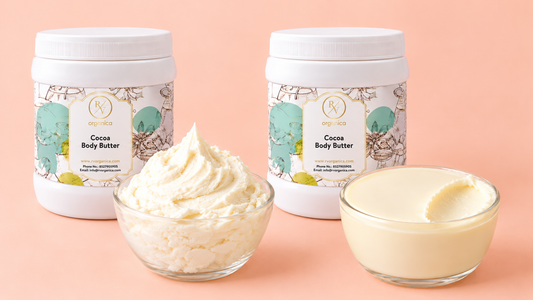 Two RV Organica Cocoa Body Butter jars on a peach background, one with a bowl of fluffy whipped butter and one with a bowl of smooth dense butter