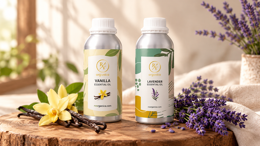 RV Organica Vanilla Essential Oil and Lavender Essential Oil bottles on a wooden slab with fresh lavender sprigs, vanilla pods and a vanilla orchid