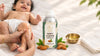 Baby receiving a gentle massage with sweet almond carrier oil, featuring RV Organica Sweet Almond Carrier Oil and almonds.