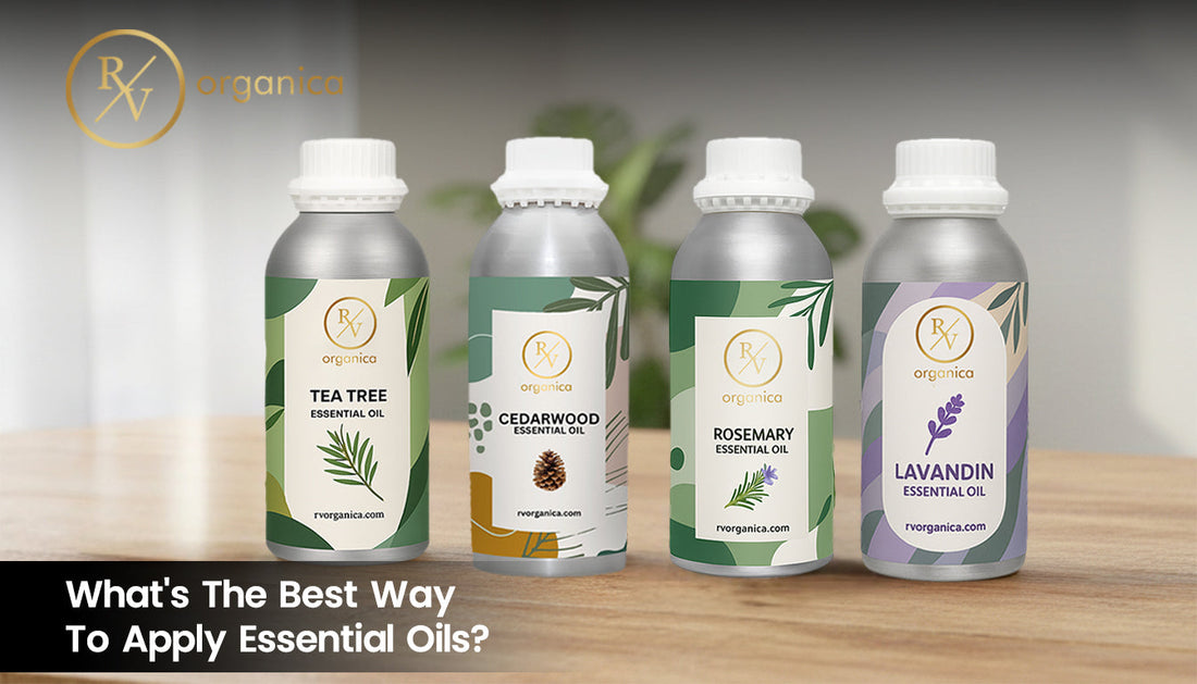 RV Organica essential oil bottles featuring Tea Tree, Cedarwood, Rosemary, and Lavandin oils displayed on a wooden table.