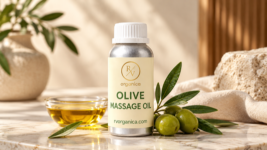 RV Organica Olive Massage Oil in premium silver bottle with green olives, olive leaves, and golden olive oil on a marble surface