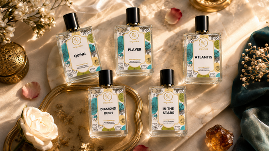 Premium RV Organica perfume oil bottles arranged in a luxurious flat lay with flowers, petals, gold accents, and marble background.