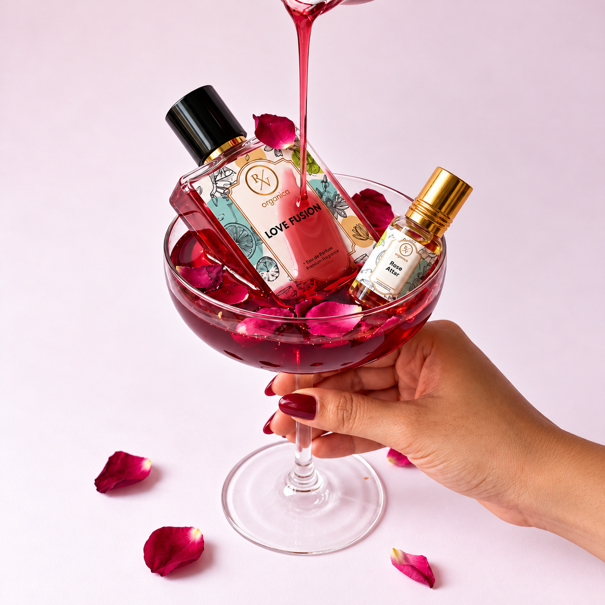 Love Fusion perfume and Rose Attar in a glass with rose petals