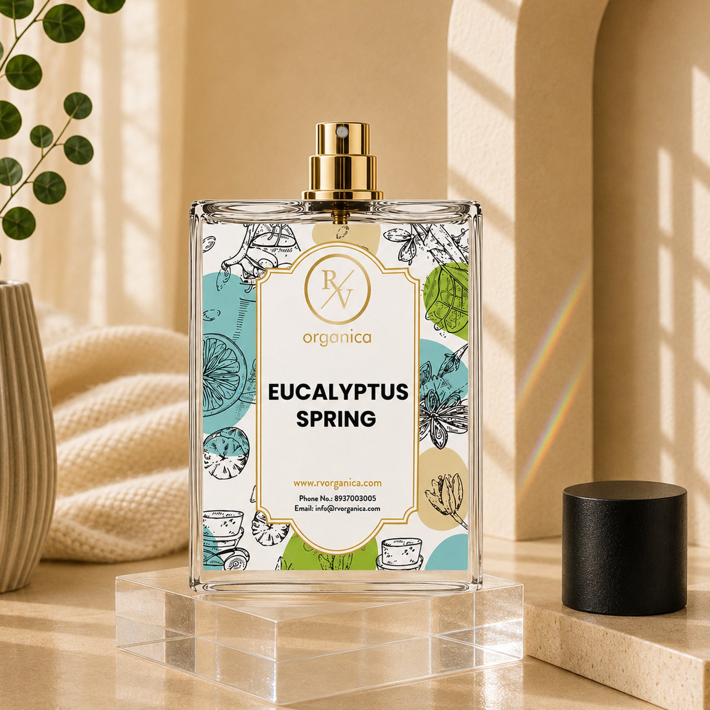 Premium Eucalyptus Spring room spray perfume bottle by RV Organica with a gold spray nozzle displayed on a clear acrylic stand in a warm, elegant indoor setting.
