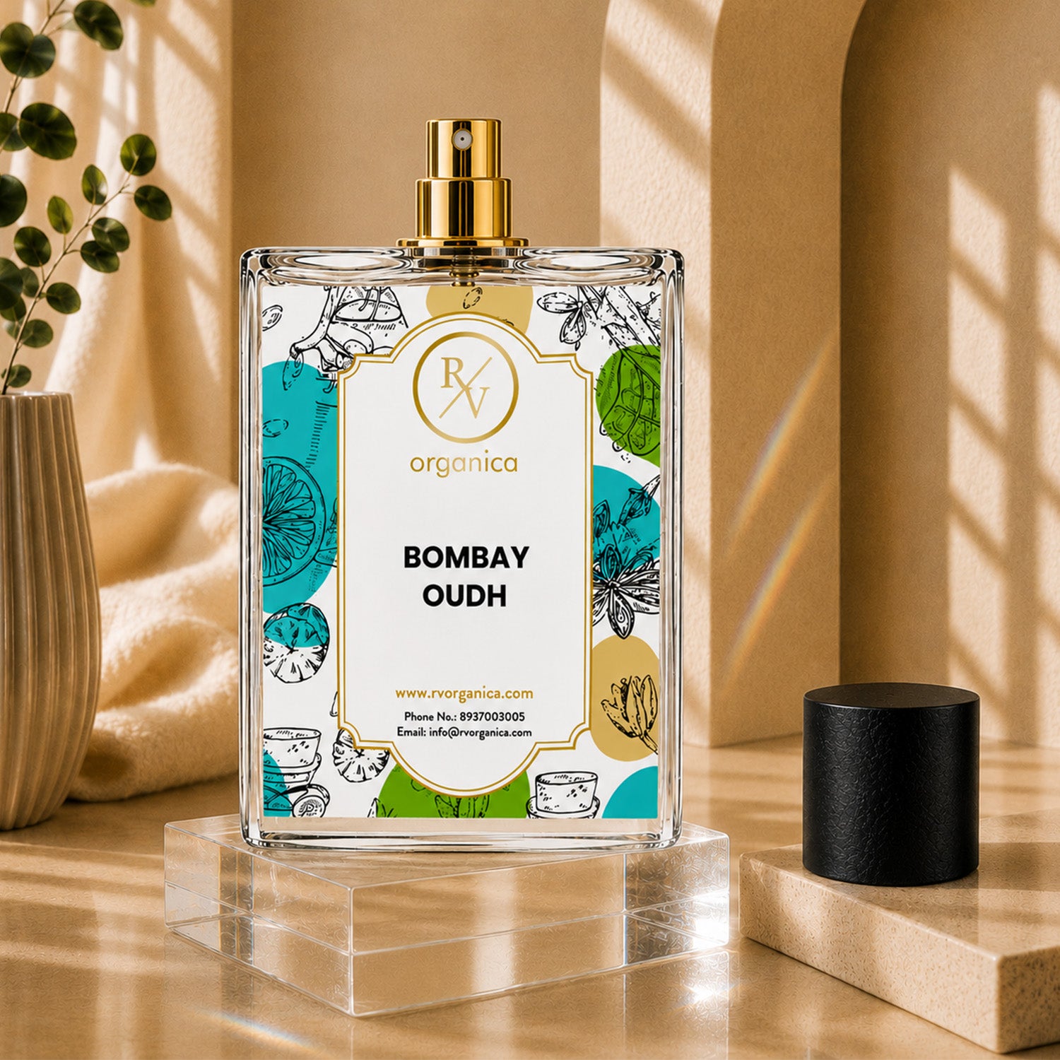 Bombay Oudh Premium Fragrance Oil by RV Organica in a clear glass bottle with a black cap, displayed on a beige stone pedestal with elegant botanical décor for luxury home fragrance and perfume making.