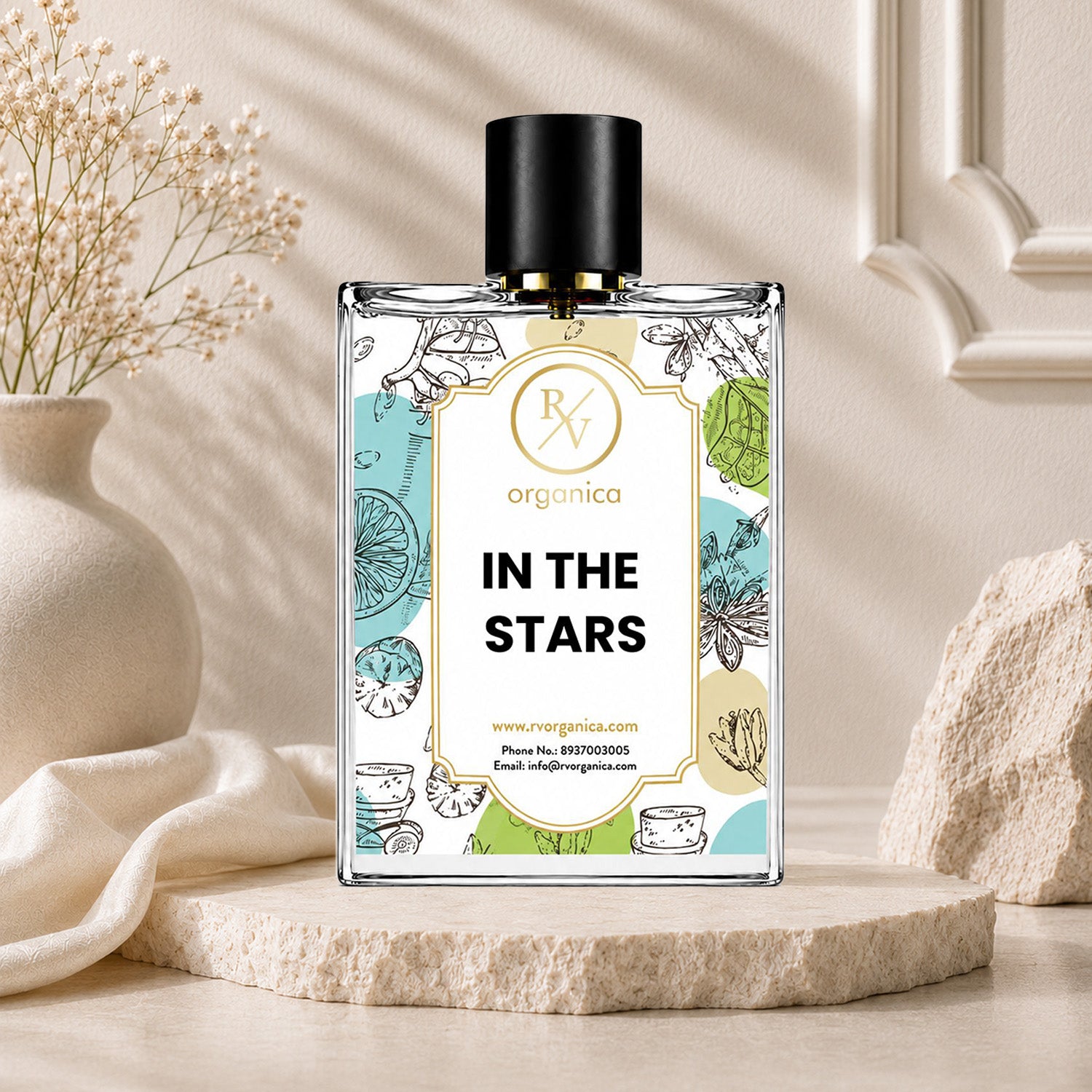 RV Organica In The Stars premium fragrance oil displayed on a natural stone pedestal with elegant beige decor and floral background.