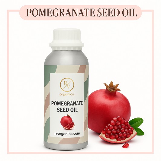 A bottle of Pomegranate Seed Oil with a fresh pomegranate and some pomegranate seeds in the foreground. The label on the bottle reads 'Pomegranate Seed Oil' and 'rvorganica.