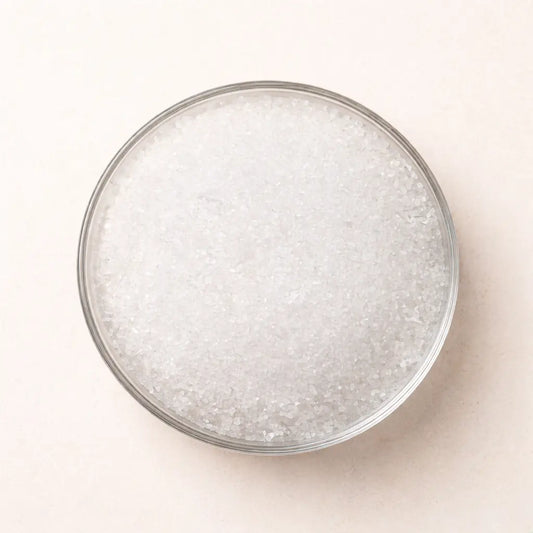 Pure Epsom salt crystals in a glass bowl, top view on neutral background