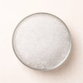 Pure Epsom salt crystals in a glass bowl, top view on neutral background