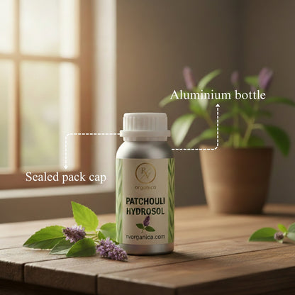 Patchouli Hydrosol in aluminium bottle with sealed cap packaging, natural organic skincare toner with fresh patchouli leaves and flowers on wooden table.
