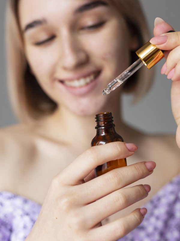 close-up-smiley-woman-with-serum